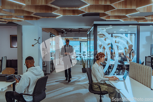 Image of Young group of business people brainstorming together in a startup space, discussing business projects, investments, and solving challenges.