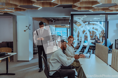 Image of Young group of business people brainstorming together in a startup space, discussing business projects, investments, and solving challenges.