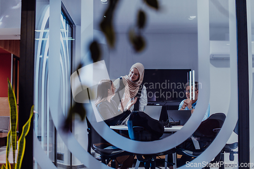 Image of A diverse group of businessmen collaborates and tests a new virtual reality technology, wearing virtual glasses, showcasing innovation and creativity in their futuristic workspace