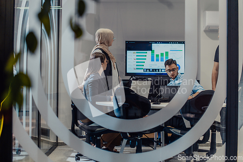 Image of A diverse group of businessmen collaborates and tests a new virtual reality technology, wearing virtual glasses, showcasing innovation and creativity in their futuristic workspace