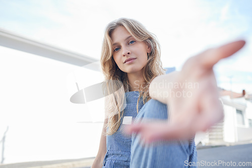 Image of Portrait of girl in the city with hand reaching forward, sitting in the street. Student, education and young woman in college with hands out in urban road. Motivation, encourage and freedom in youth