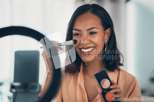 Image of Beauty influencer, vlogger or podcast host teaching with a phone to film live stream makeup tutorial with blush makeup brush and palette. Happy woman use technology to promote cosmetic product online