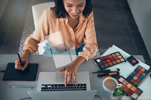 Image of Graphic designer designing marketing advert for beauty products, makeup and cosmetics on laptop from above. Top view of smiling entrepreneur or freelance worker checking creative work