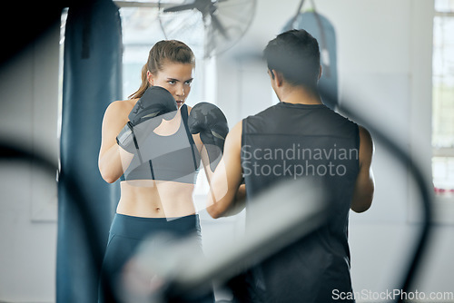 Image of Boxing fitness training with coach at gym, angry woman learning self defense with trainer and learning cardio exercise for wellness at sports club. Male instructor teaching workout class at center