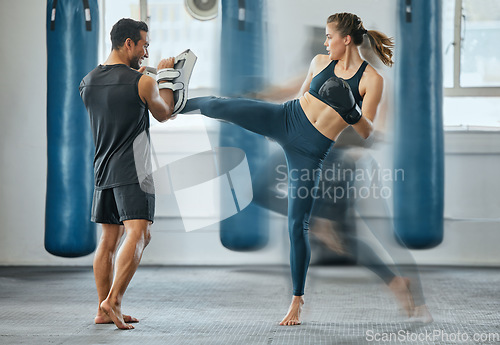 Image of Fighting female training with coach, learning kickboxing exercise at gym and doing cardio fitness workout for wellness with trainer at health club. Woman and man staying, active, healthy and sporty