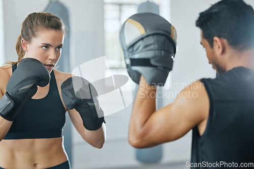 Image of Boxing female boxer at gym with sports personal trainer practicing or training together for fight or match. Fitness and wellness coach teaching fit active athlete or client fighting exercise workout