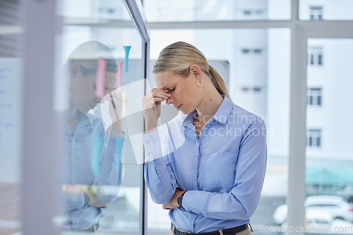 Image of Sad, burnout and worried business woman with a work stress headache at an office. Corporate finance manager working overtime with anxiety about an accounting audit, financial tax and job project