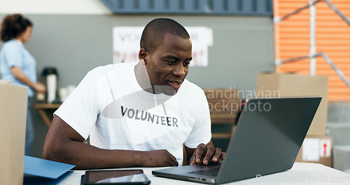 Image of Volunteer man, laptop and reading for donation, clothes drive and smile for community service, scroll and web. African person, pc and social responsibility with boxes, charity and ideas for helping