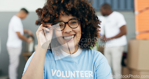 Image of Volunteer woman, portrait and smile for charity, clothes drive and community service with kindness at desk. African girl, ngo and social responsibility with donation boxes, care or happy for helping