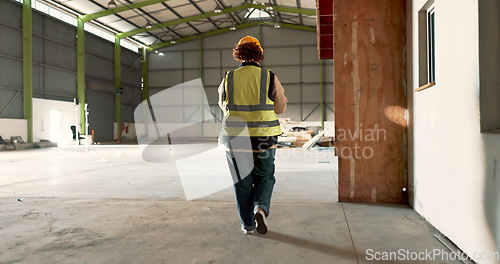 Image of Warehouse, back of woman and engineer walking at empty industrial plant, manufacturing production or construction. Factory, rear view and worker or technician check storage, distribution or logistics