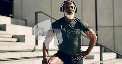 Image of Fitness, headphones and black man on stairs in city, sweat after workout and exercise for body health. Music, senior athlete and steps in urban town, listening to audio and serious, thinking or tired