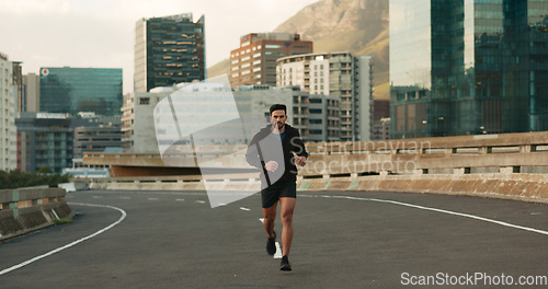 Image of Athlete, morning and running in city street, road and bridge for fitness, workout and marathon training. Man, person or exercise in South Africa for cardio wellness, health or triathlon performance