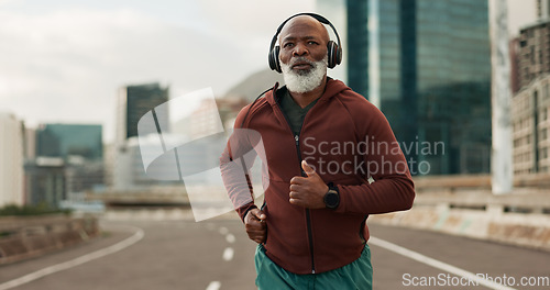 Image of Mature, person and running in city with headphones for fitness, workout and marathon training music. Black man, athlete or exercise podcast in South Africa for cardio wellness, health or sports radio