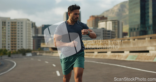 Image of Running, road or man for time in training, practice or fitness goals for marathon competition. Indian athlete, wellness or speed runner in cape town race in watch progress, city street or health body