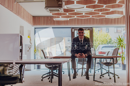 Image of A businessman sitting on his desk, taking a moment to rest and unwind from a demanding workday, displaying a sense of tranquility and relaxation amidst the corporate environment