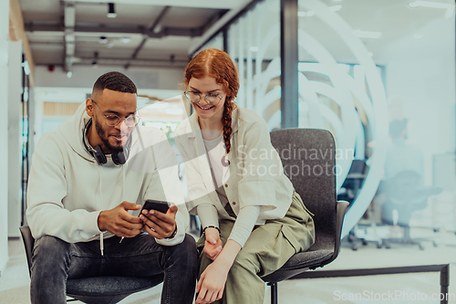 Image of In a modern office African American young businessman and his businesswoman colleague, with her striking orange hair, engage in collaborative problem-solving sessions