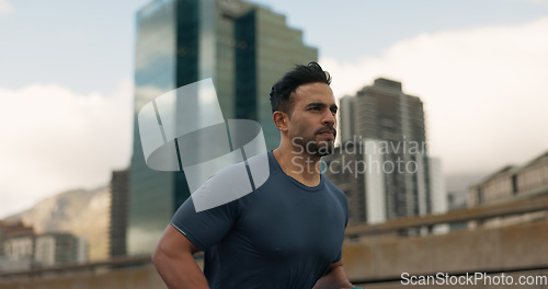 Image of Workout, running and a sports man in the city for cardio training to improve fitness for a marathon. Wellness, exercise or health with a young runner or athlete in an urban town for a speed challenge