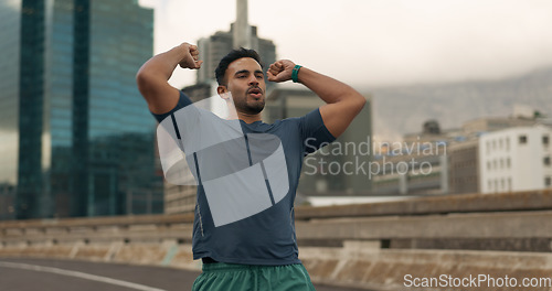 Image of Fitness, winner and a sports man in the city for marathon running to improve cardio performance. Exercise, success and workout goals with a young runner or athlete on a bridge in an urban town