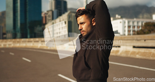 Image of Man, stretching and fitness in city for exercise, workout or outdoor training on road or street. Active male person, runner or athlete in body warm up or arm stretch getting ready in an urban town