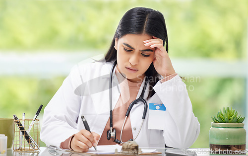 Image of Stress, anxiety and worry of a busy working woman doctor writing patient, medical and hospital data. Female healthcare professional burnout feeling stressed from a work headache and report deadline