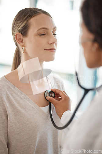 Image of Checking and hearing heart rate with a working doctor consulting the wellness and health of a woman. Clinic checkup with a medical professional and patient at a healthcare center or hospital