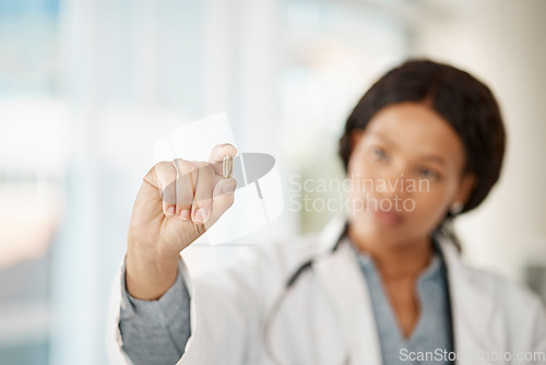 Image of Medical doctor with medicine pills in hand while working in a hospital or clinic. Woman healthcare professional or expert showing oil capsule, vitamin or omega 3 supplement in hospital or pharmacy