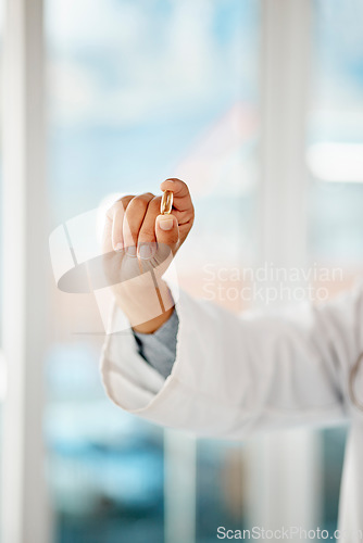 Image of Hand holding medicine, tablet and healthcare doctor holding a pill for remedy, cure for sickness and medication for good health. Closeup of a medical professional showing a vitamin or supplement