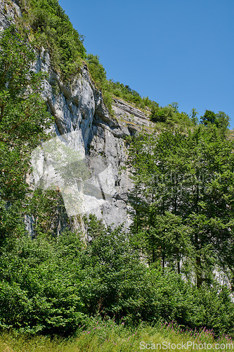 Image of Landscape mountain view of steep stone cliffs and lush green foliage with trees in remote countryside or a nature reserve. Environment conservation of scenic hiking rock climbing location for tourism