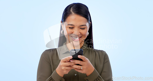 Image of Business, woman or phone in studio with smile for text message, networking and internet chat on blue background. Person, smartphone or technology for scrolling on website or web search with happiness