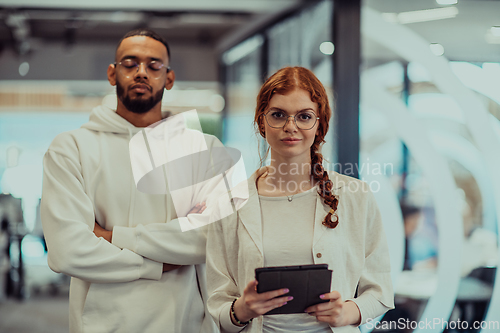 Image of In a modern office African American young businessman and his businesswoman colleague, with her striking orange hair, engage in collaborative problem-solving sessions