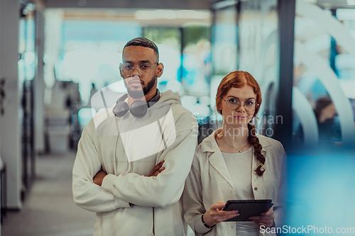 Image of In a modern office African American young businessman and his businesswoman colleague, with her striking orange hair, engage in collaborative problem-solving sessions