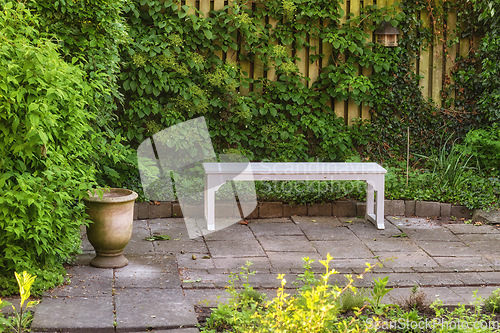 Image of Gardeners corner. Private chair in green garden in the beautiful outdoors. A place with green nature views outside. Resting area for relaxation and isolated seating area surrounded by natural life.