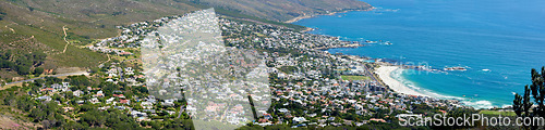 Image of Panoramic landscape of a large city on the coast from above. Beautiful scenic and aerial view of a popular tourist town or residential area with greenery and the ocean in nature during summer