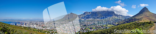 Image of Panoramic scene of Cape Town, South Africa. Table Mountain, Lions Head and Signal Hill against a blue sky background, overlooking the city. Aerial view of the urban and natural environments