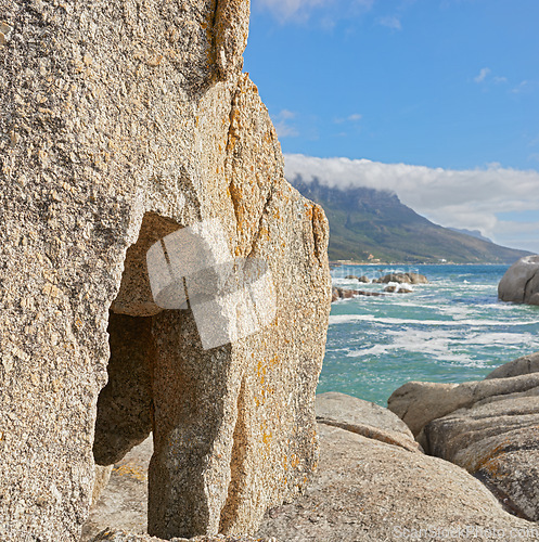 Image of Landscape of rocks and the ocean in Camps Bay, Cape Town, South Africa. Scenic view of big rocks on the shoreline of the beach in summer. Large stones in the sea at famous tourist destination