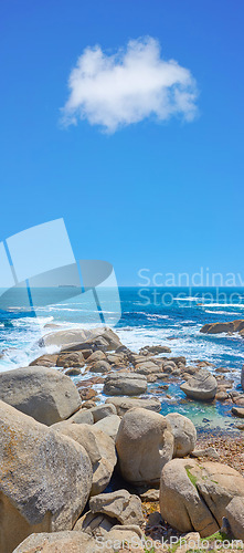 Image of Boulders at a beach shore with majestic ocean across the horizon. Copyspace at sea with blue sky background and rocky coast in Camps Bay, South Africa. Calm and scenic landscape for a summer holiday