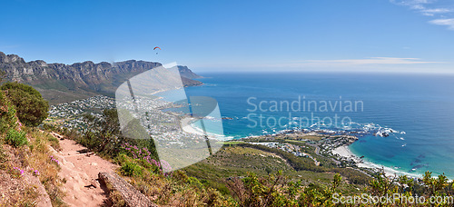 Image of Scenic hiking trail along Table Mountain with beautiful views of a coastal city against a blue sky background. Magnificent panoramic of peaceful and rugged landscape at the sea to explore and travel