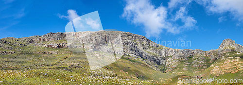 Image of Widescreen landscape view of Table Mountain in Cape Town, South Africa. Low panoramic scenery of a popular natural landmark and tourist attraction during the day against a blue cloudy sky in summer