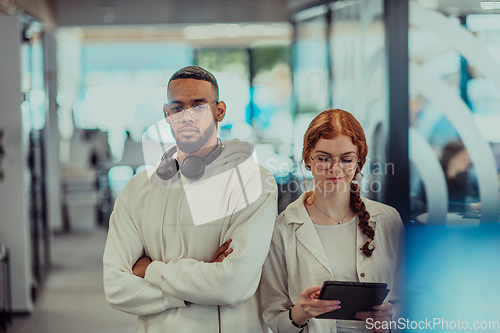 Image of In a modern office African American young businessman and his businesswoman colleague, with her striking orange hair, engage in collaborative problem-solving sessions