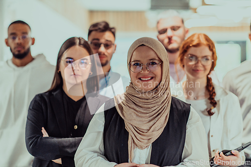 Image of A group of young business professionals stands together, taking a well-deserved break from their busy workday, showcasing camaraderie, teamwork, and a moment of relaxation in their dynamic workplace