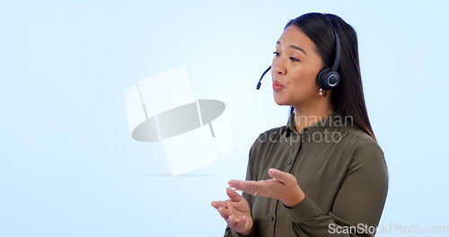 Image of Space, customer service and support with an asian woman talking in studio on a blue background. Contact us, crm or consulting with a young call center employee telemarketing on a headset for help