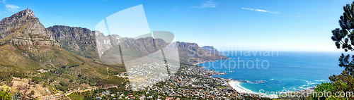 Image of Beautiful coastal landscape with mountains surrounded an urban city in a popular tourism destination. Aerial view of Cape Town city with Mountain outcrops and the ocean on a blue sky with copy space