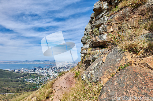 Image of Copyspace landscape view of mountain trails on Lions Head, Table Mountain National Park in Cape Town, South Africa. Natural landmark for hiking and fitness walks against a cloudy blue sky in summer