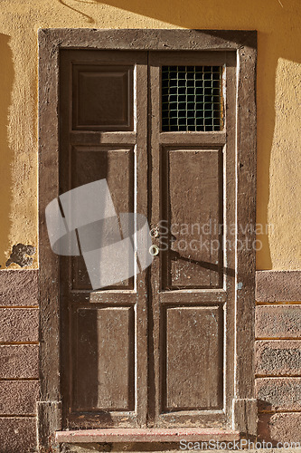 Image of Weathered and damaged architectural structure with rustic, aged pattern and frame on an entrance or doorway in Spain. An old wooden vintage door of an ancient building in Santa Cruz de La Palma.