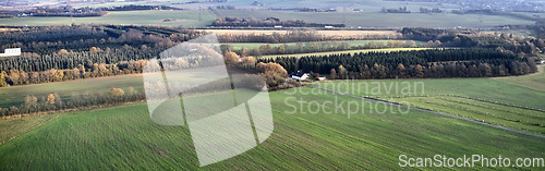 Image of Green landscape of a countryside with autumn colors. Aerial view of a sustainable, cultivated farmland or flat land with grass surrounded by a traditional farm house and lots of forest trees