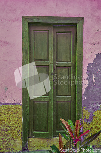 Image of Vintage, aged structure with architectural details on moss covered walls in an urban town in Spain. A door at an entrance of an old fashioned rustic building in Santa Cruz, de La Palma.