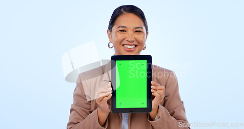 Image of Portrait, tablet and green screen space with an asian woman in studio on a blue background for website promotion. Tech, mockup or chromakey and a person holding a display with tracking markers