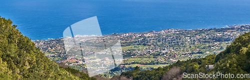 Image of Landscape of a coastal city between hills and mountains from above. A peaceful village beside calm blue ocean water in the Canary Islands. High angle view of Los Llanos, La Palma in summer