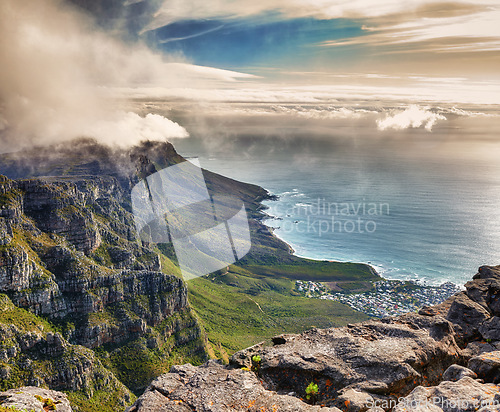 Image of Aerial view of clouds rolling over Table mountain in Cape town, South Africa with copyspace. Beautiful landscape of green bushes and rocky terrain on misty morning, calming view of the ocean and city