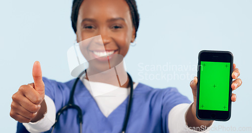 Image of Green screen, thumbs up and portrait of doctor with phone for telehealth, wellness app and medical news. Healthcare, clinic mockup and black woman with smartphone and emoji sign for website in studio